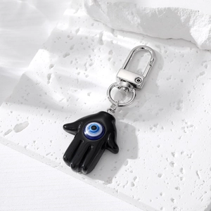 Porte-clés Main de Fatma avec pendentif œil bleu sur fond de pierre blanche