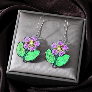 Detailed macro view of purple acrylic flower earrings with green leaves on satin