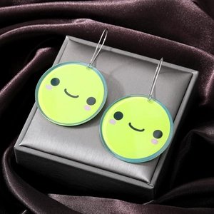 Cute green acrylic smile face round earrings with silver metal hooks on jewelry box