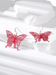 Red butterfly cutout drop earrings with intricate floral pattern on white stones