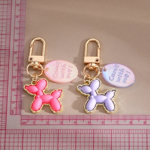 Top view of pink and purple balloon dog keychains with measuring ruler for size detail