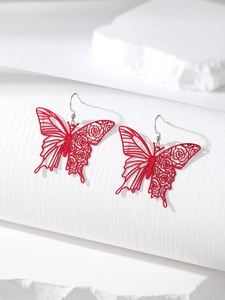Close-up of red butterfly cutout earrings with rose floral patterns on display stand