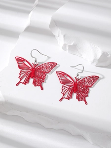 Detailed macro view of matte red hollow butterfly earrings with floral filigree design