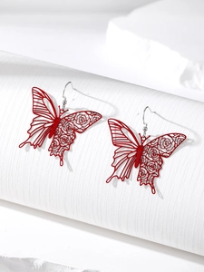 Detail shot of a vibrant red butterfly earring with intricate rose floral hollow pattern