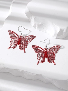 Detail of red butterfly drop earrings with hollow rose pattern on white stone base