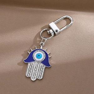 Porte-clés Main de Fatma avec œil bleu maléfique et cristaux étincelants sur satin