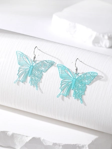 Detail shot of light blue cutout butterfly earrings with laser-cut wing patterns