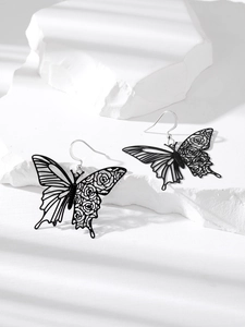 Elegant cutout black butterfly earrings with intricate rose pattern on textured stone base