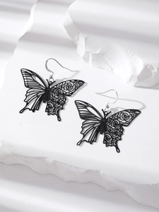 Detailed view of black hollow butterfly earrings with rose patterns on stone surface