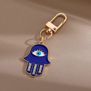 Détail du porte-clés main de Hamsa avec œil bleu et strass blancs étincelants