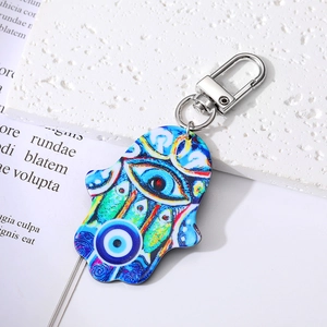 Macro detail of Hamsa Hand keychain with Evil Eye pattern on acrylic material and metal hook