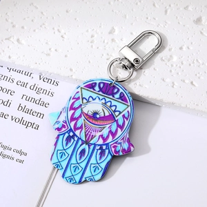 Detail eines Hamsa-Hand-Schlüsselanhängers im Boho-Stil mit Evil Eye Muster auf Stein