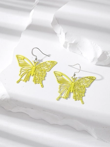 Detail of bright yellow butterfly earring with hollow rose patterns on a textured stone