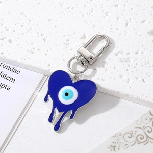 Détail du porte-clés cœur bleu avec œil protecteur sur une surface en marbre texturé
