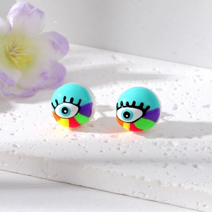 Close-up of pearl stud earrings with colorful evil eye graffiti and rainbow pattern
