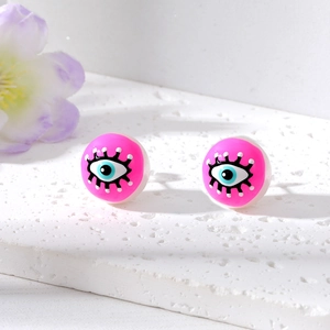 Macro shot of pink evil eye stud earrings with pearl details and painted eyelashes