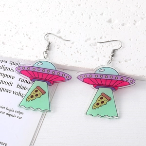 Detail view of colorful acrylic UFO and pizza earrings with silver hooks on white stone