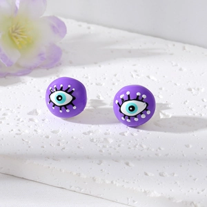 Fashionable purple evil eye pearl studs with graffiti design on white stone background