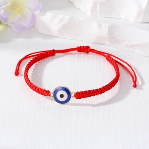 Detail of red braided Evil Eye bracelet with blue pendant and adjustable knot closure