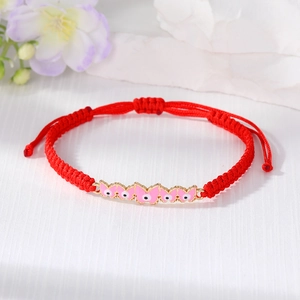 Handmade red braided cord bracelet with pink butterfly and evil eye charms for good luck