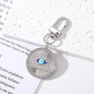 Silver Evil Eye Hamsa Hand keychain with crystal heart and pyramid charm on white background