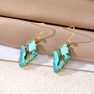 Detailed close-up of blue geometric crystal leaf earrings with gold metal hooks and zircons