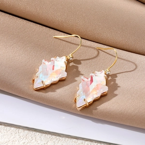 Detailed macro shot of iridescent crystal drop earrings with gold hooks on fabric