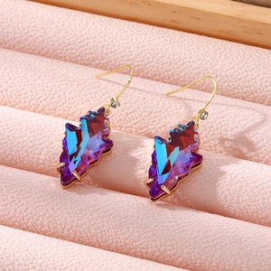 Elegant geometric iridescent crystal leaf earrings with gold hooks on a pink jewelry tray