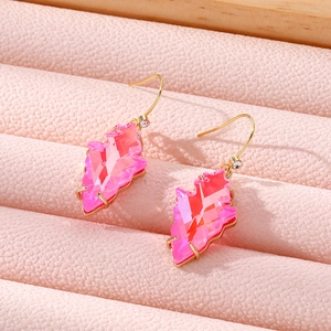 Macro shot of geometric pink crystal earrings on a pink leather jewelry display tray