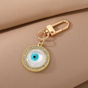 Golden Evil Eye keychain with blue eye motif and sparkling rhinestones on fabric