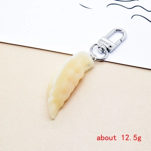 Detailed close-up of a realistic dumpling keychain with a weight label of about 12.5g