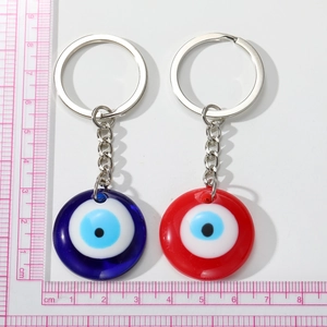 Blue and red Evil Eye resin keychains with silver metal rings on a white background
