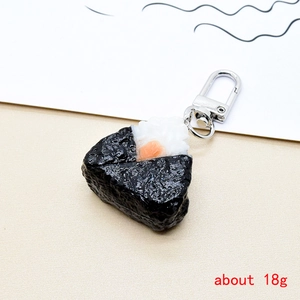 Detail view of a realistic resin onigiri rice ball keychain with seaweed and silver clasp