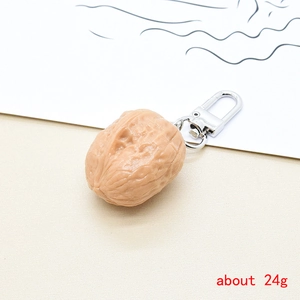 Detailed view of realistic walnut keychain made of resin with silver metal clasp