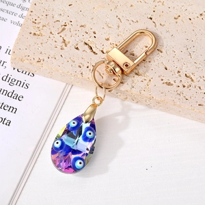 Blue crystal Evil Eye keychain with teardrop charm and golden clasp on stone