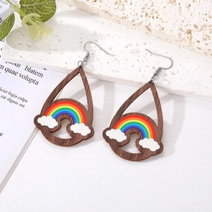 Detail view of wooden teardrop earrings with hand-painted rainbow and cloud patterns
