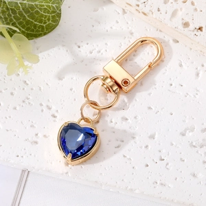 Macro detail of heart-shaped blue crystal keychain with gold-plated spring clasp