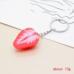 Detailed macro view of a 13g resin strawberry keychain with realistic pulp and seeds