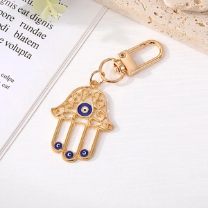 Portachiavi mano di Fatima dorata con ciondoli Evil Eye blu e motivi floreali traforati