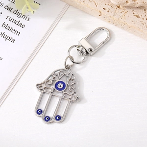 Dettaglio portachiavi mano di Fatima con occhi blu e lavorazione del metallo traforato