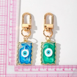 Blue and green evil eye pendants with gold wavy edges and lobster clasp keychains