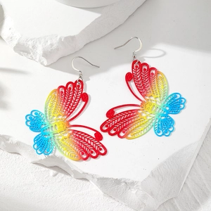 Regenbogenfarbene hohle Schmetterlings-Ohrhänger auf weißem strukturiertem Stein