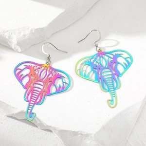 Detailed view of rainbow-plated elephant dangle earrings on a textured stone surface