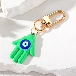Detalle de llavero de mano de Hamsa verde con ojo turco azul y cierre de metal dorado