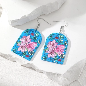 Retro-Ohrringe aus Acryl mit blauen Bögen und rosa Blumenmustern auf Marmorhintergrund