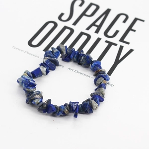 Dettaglio del bracciale bohémien in lapislazzuli su uno sfondo bianco in stile minimalista