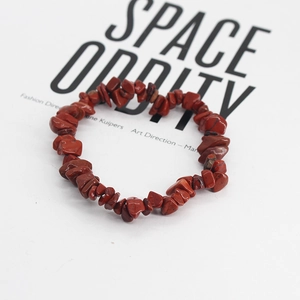 Dettaglio ravvicinato di un bracciale stretch bohémien con pietre naturali di diaspro rosso