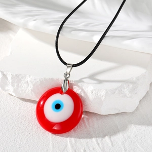 Collier bohème avec pendentif œil protecteur rouge en résine sur fond de pierre blanche