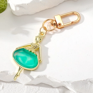 Détail du porte-clés ballerine avec monture dorée et robe en émail vert de haute qualité