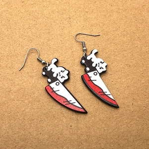 Detailed shot of creative gothic acrylic earrings featuring a cat on a bloody dagger pendant